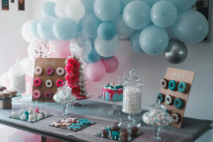 A dessert table with a donut display, cake, and treats