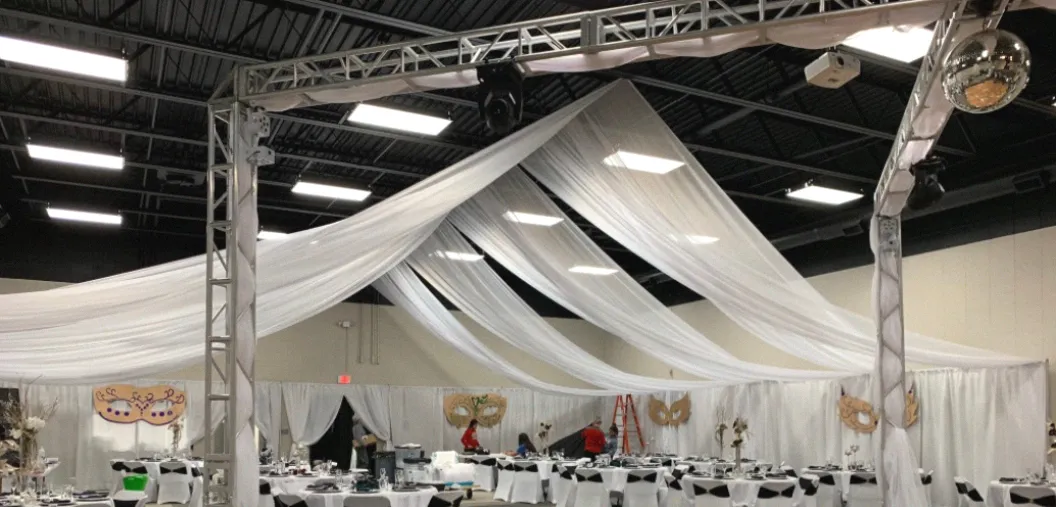 The SandHills reception hall set with tables and string lights for a wedding